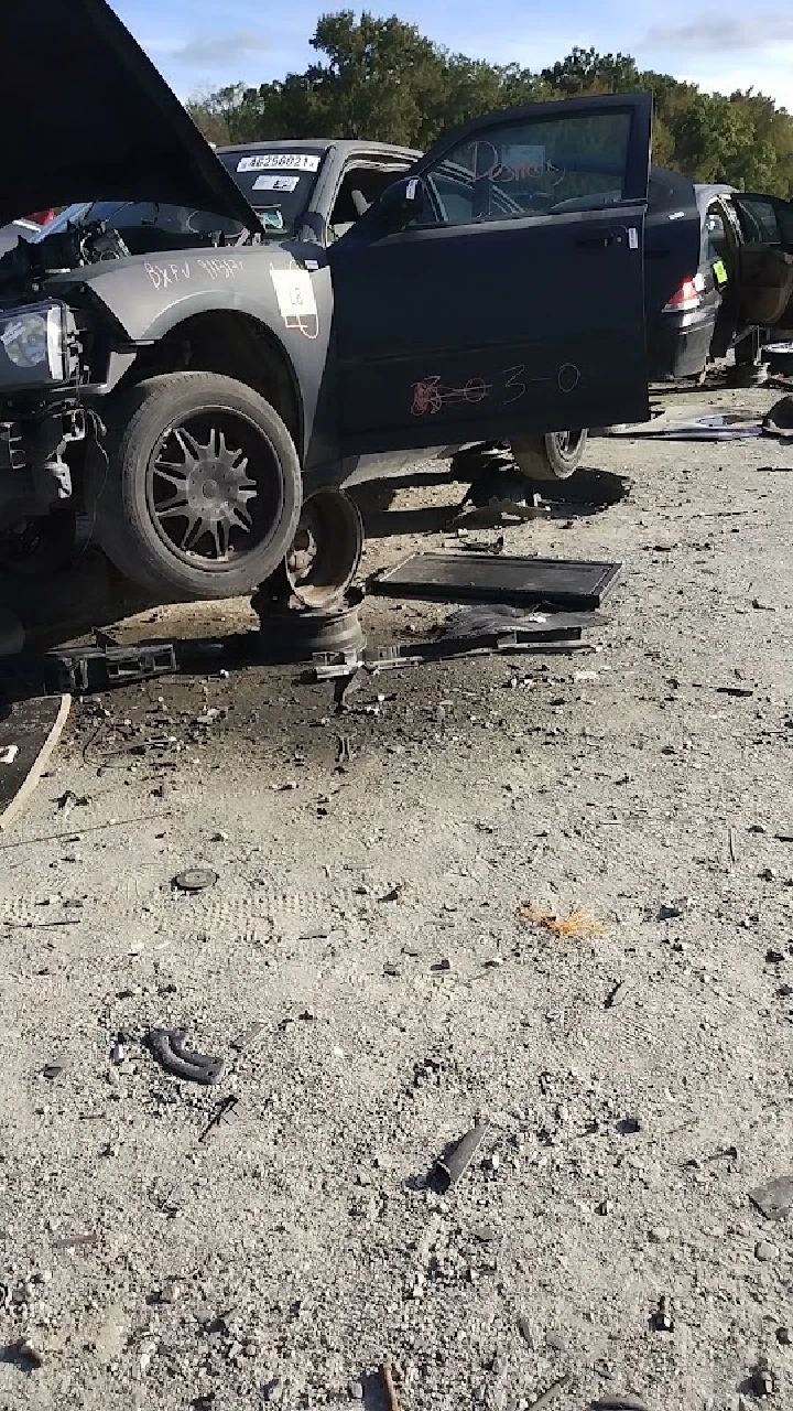 Junkyard scene with dismantled cars and debris.