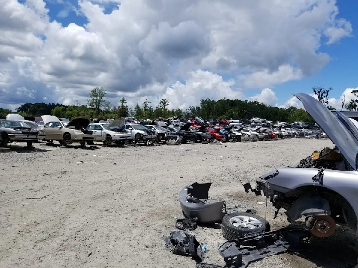 Scrapyard filled with abandoned vehicles and parts.