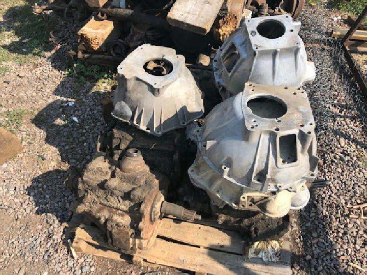 Two metal engine parts on a wooden pallet.