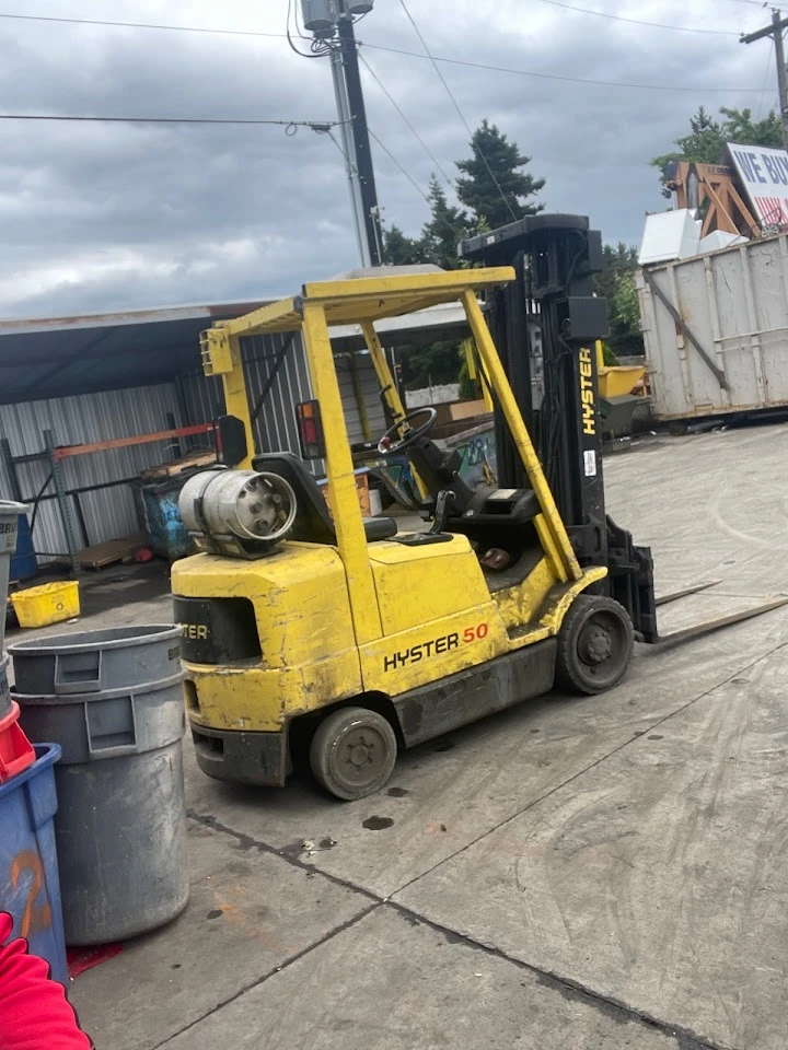 Yellow Hyster forklift in a recycling yard.