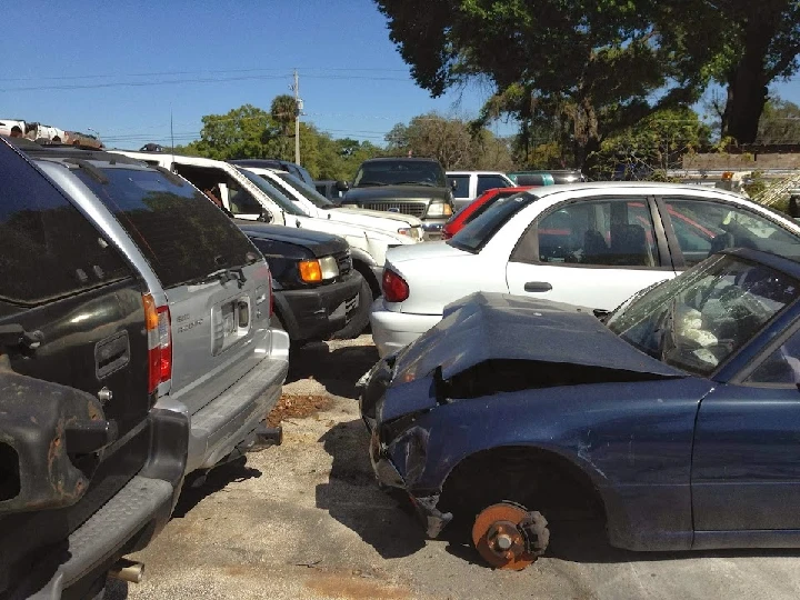 Abandoned cars in a junkyard lot.