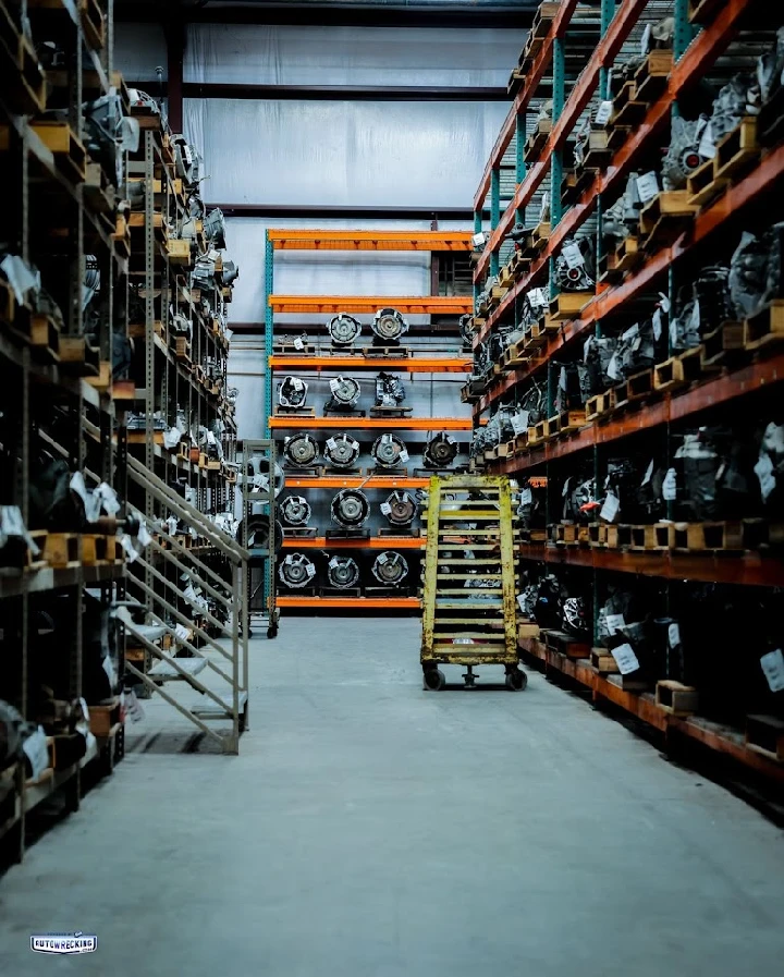 Auto parts warehouse with shelves of engines and tools.