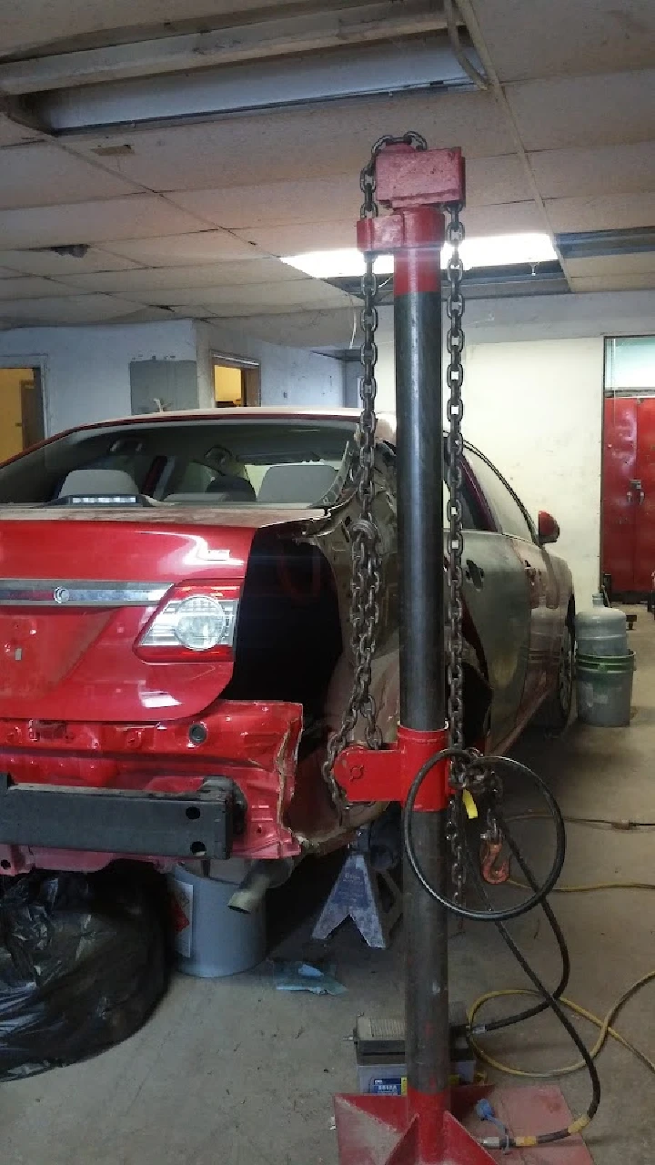 Auto repair shop with a vehicle on a hoist.