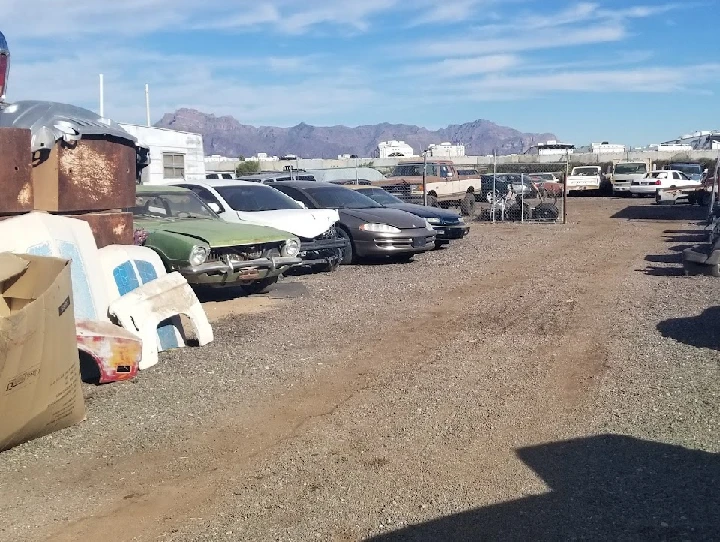 Auto salvage yard filled with discarded vehicles.