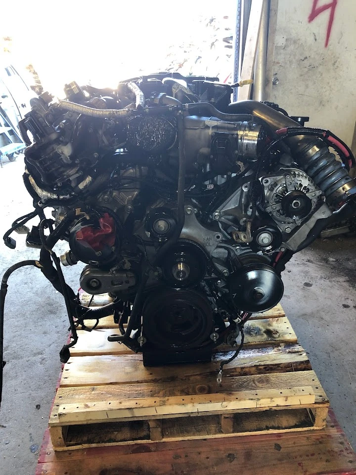 Automobile engine on a wooden pallet in a workshop.