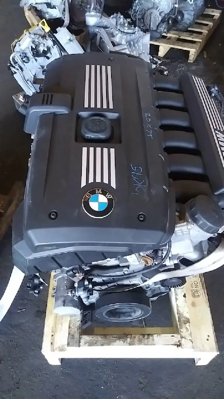 BMW engine on a wooden pallet at auto parts shop.