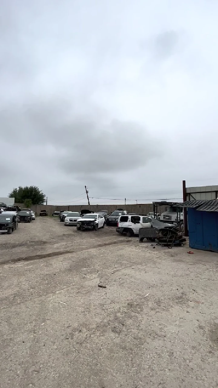 Car dismantling yard with various vehicles.