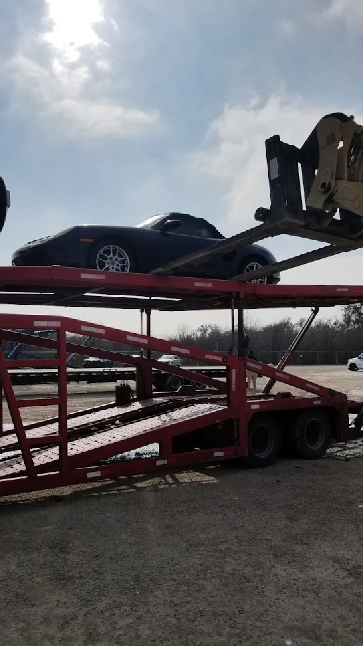 Car being loaded onto a trailer at auto salvage yard.