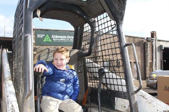 Child sitting in a loader at Alderman-Dow Iron & Metal.