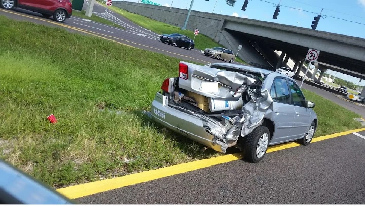 Damaged car abandoned on roadside.