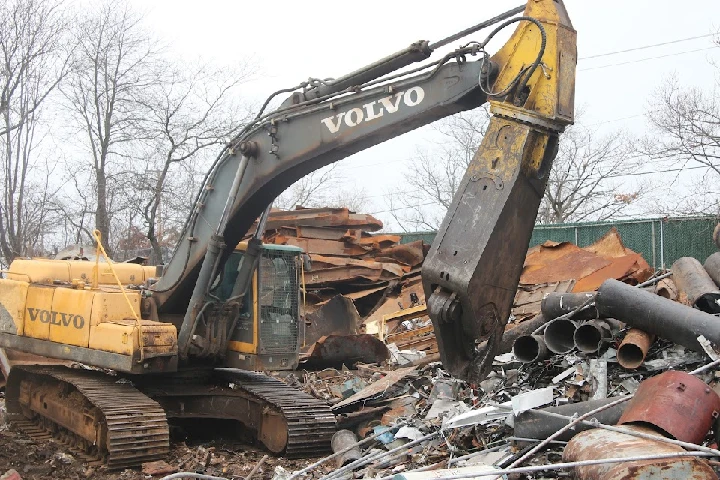 Excavator at an iron and metal recycling site.