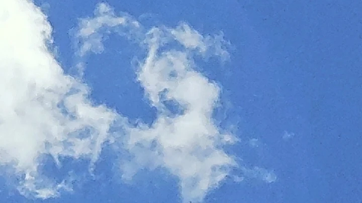 Fluffy clouds against a bright blue sky.