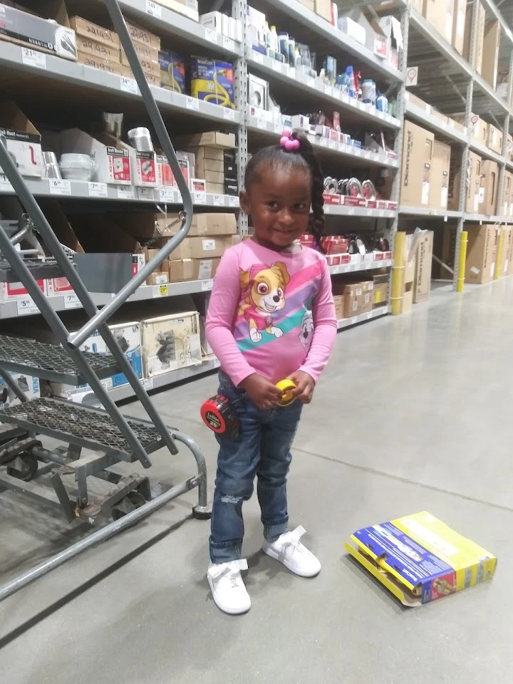 Girl smiling in an auto parts store aisle.