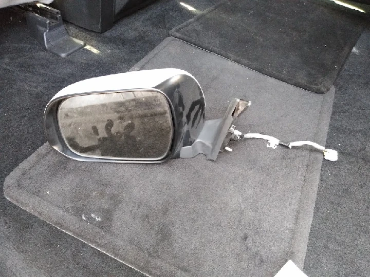 Jeep side mirror on a carpeted surface.