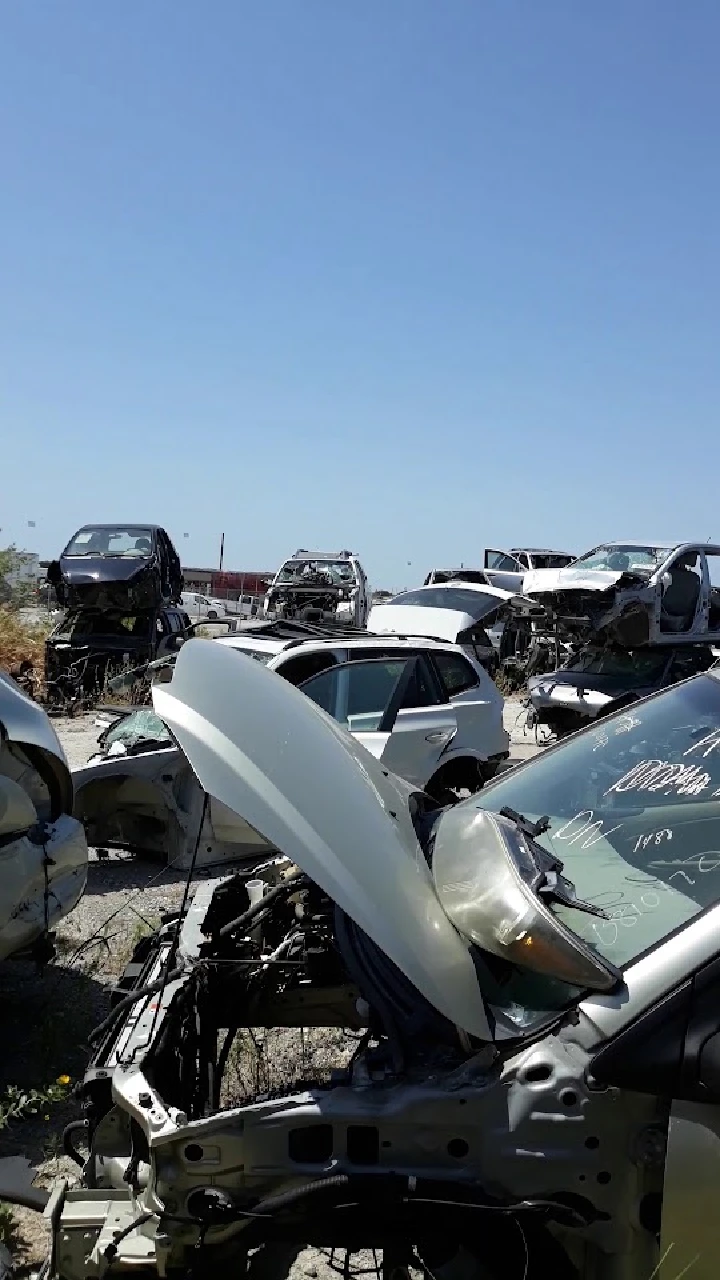 Junkyard filled with abandoned cars and auto parts.