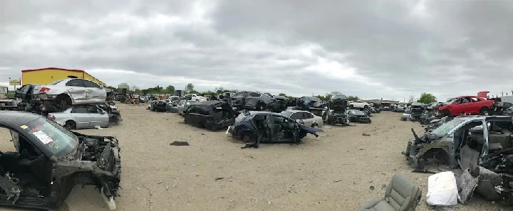 Junkyard with numerous dismantled vehicles.