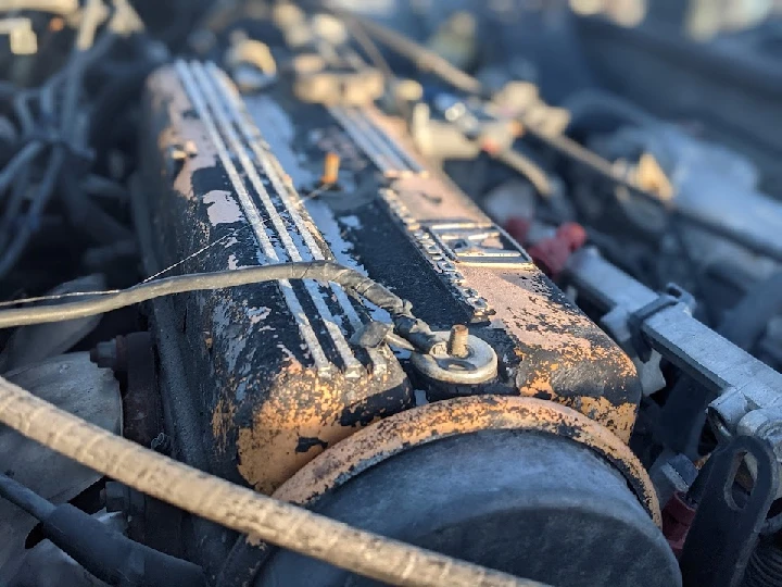 Old car engine with rust and worn components.