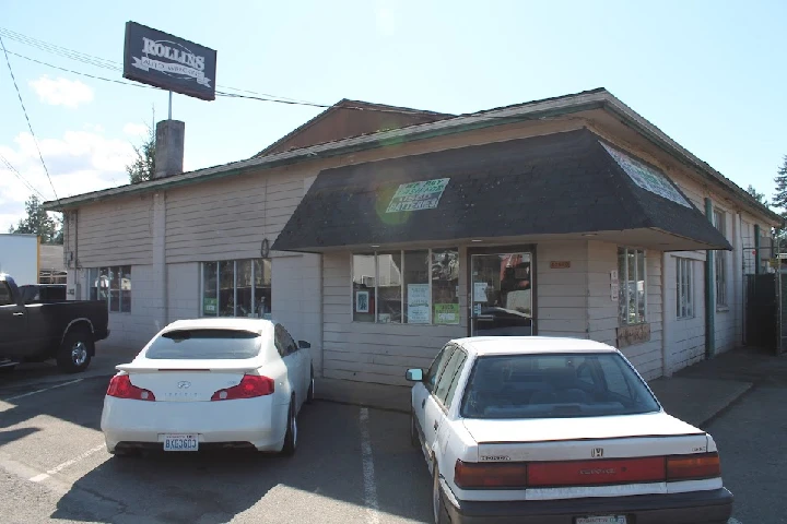 Rollins Auto Wrecking building with parked cars.