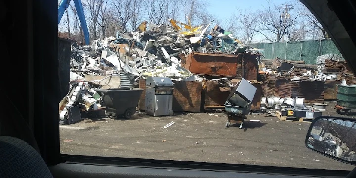 Scrap metal yard with piled debris and equipment.