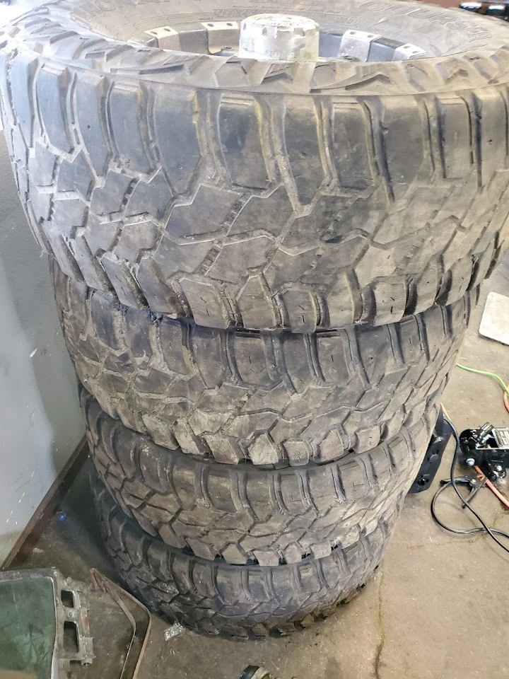 Stack of used tires in an auto wrecking yard.