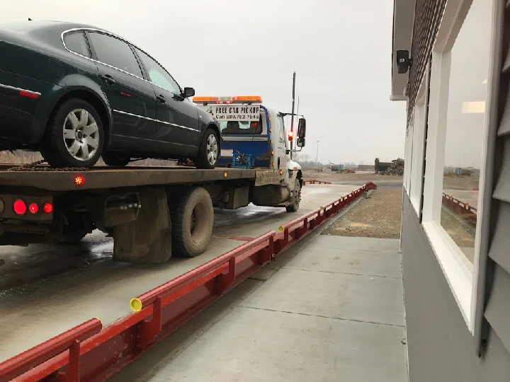 Tow truck loading a vehicle at scrap yard.