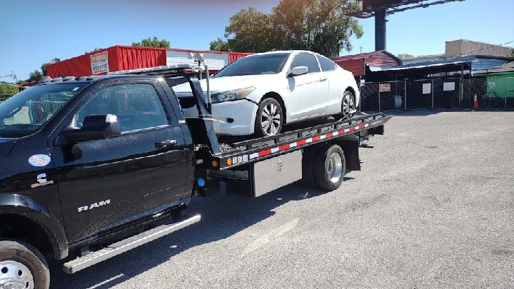 Tow truck transporting a junk car for Lifa.