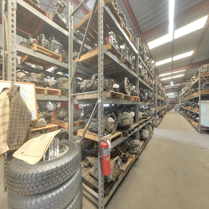 Used auto parts stacked on shelves in a warehouse.