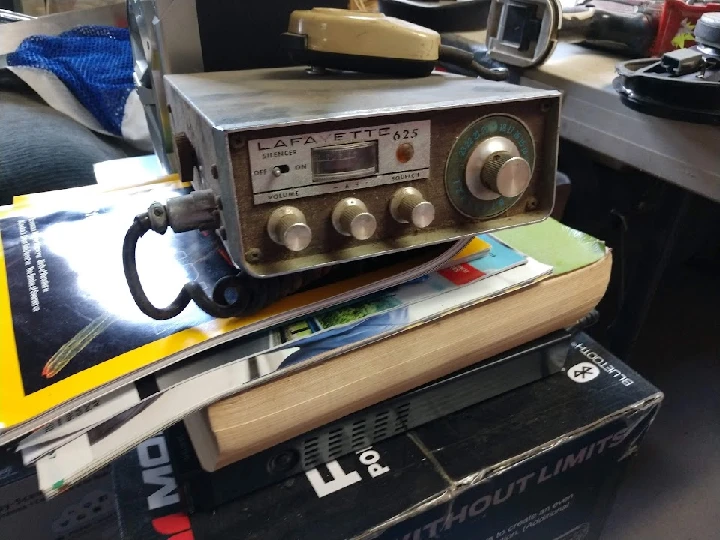 Vintage radio on stacked magazines and boxes.