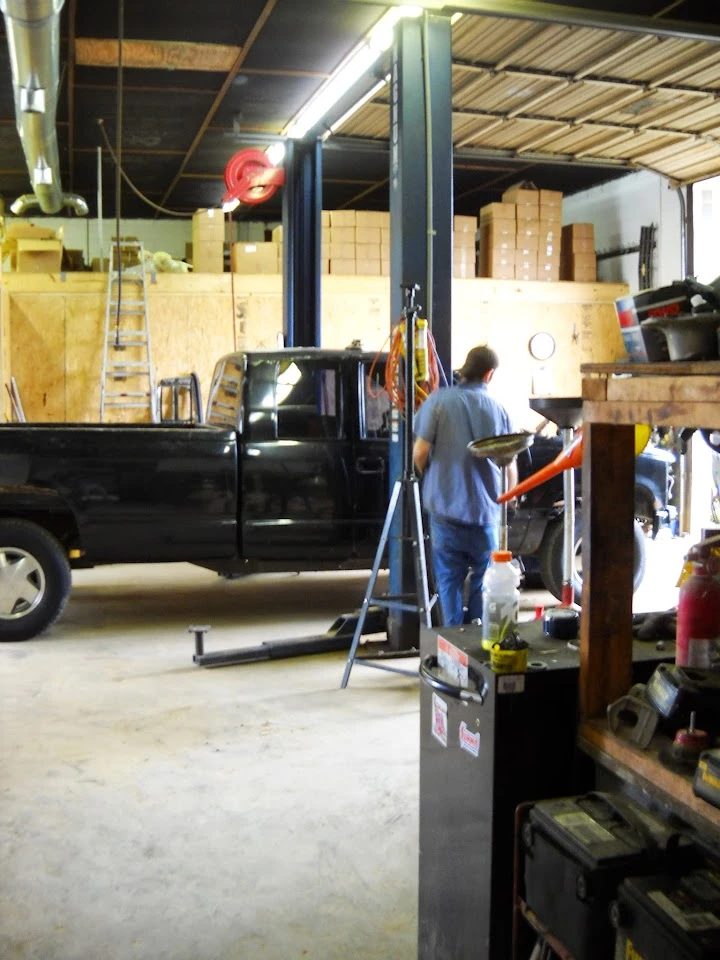 Auto parts shop with a mechanic working on a truck.