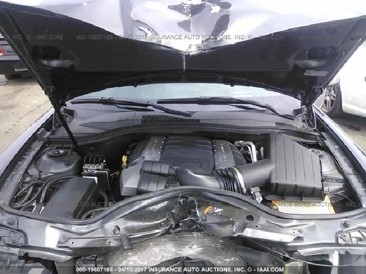 Car engine view from an open hood at a dismantler.