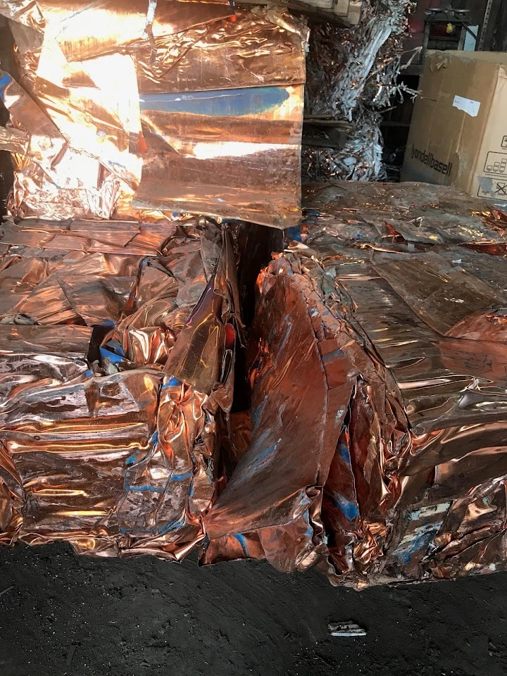 Copper scrap metal bales stacked in a warehouse.