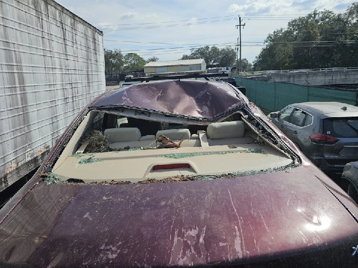 Damaged junk car with shattered rear window.