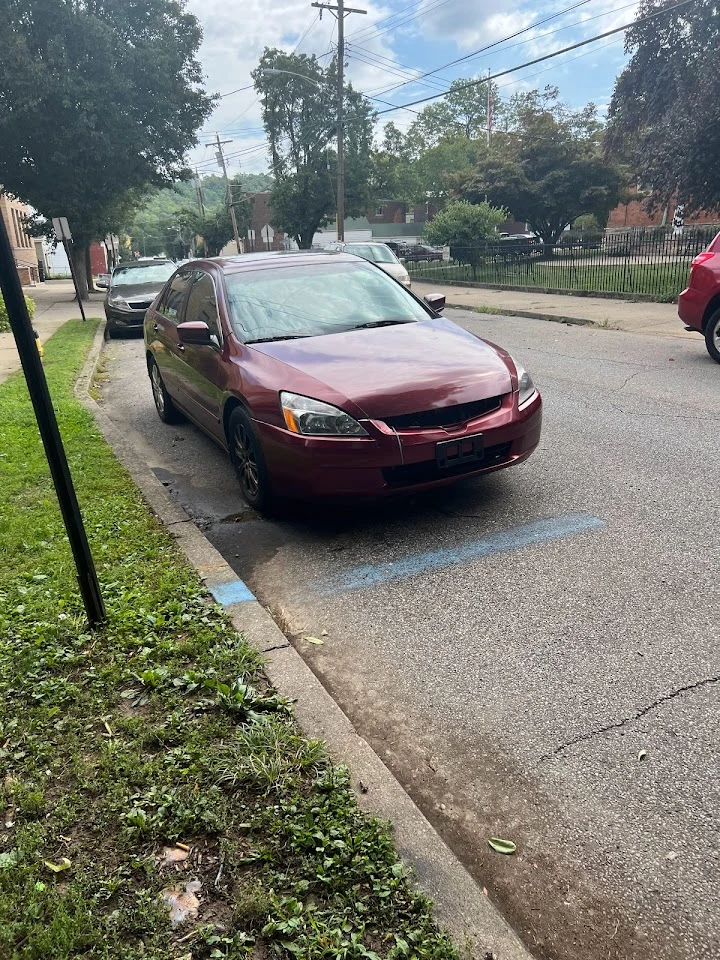 Red sedan parked on a city street.