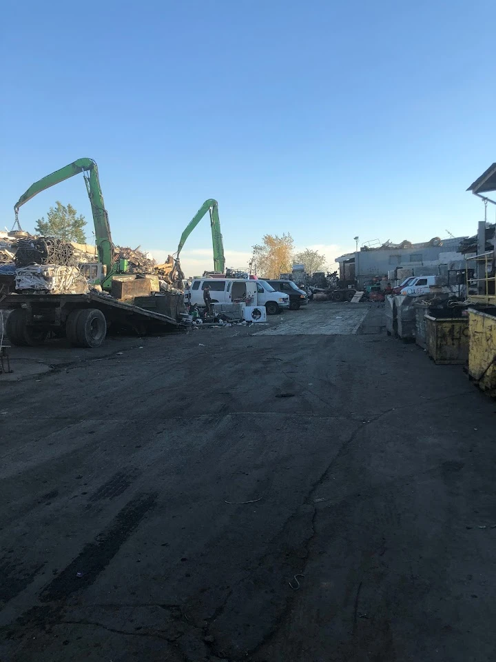 Scrap metal yard with machinery and vehicles.