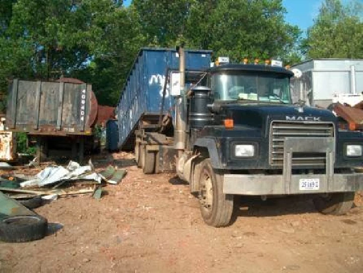 Truck at a recycling yard with metal containers.