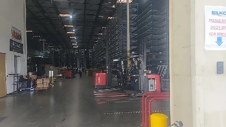 Warehouse interior with storage racks and forklifts.