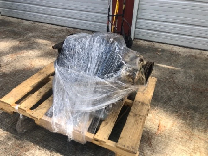 Wrapped auto part on a pallet outdoors.