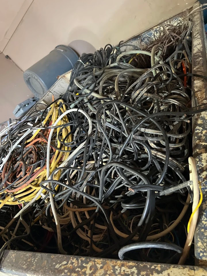 A pile of tangled wires in a recycling bin.