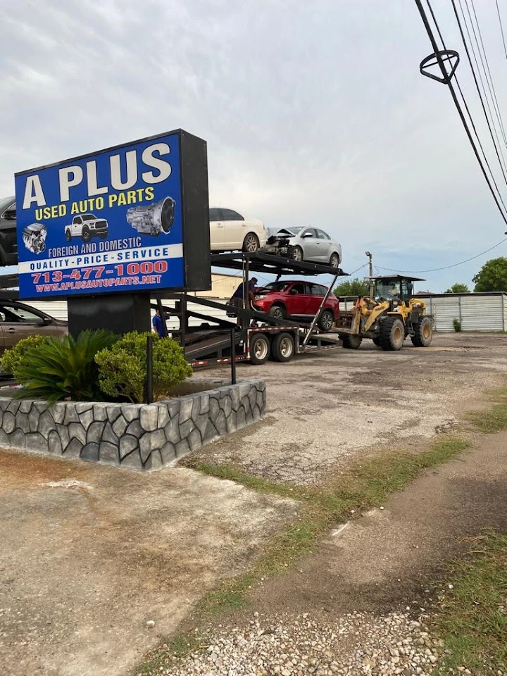 A Plus Auto Parts with cars on a transport trailer.