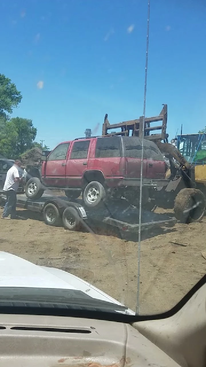 A red SUV being loaded onto a trailer.