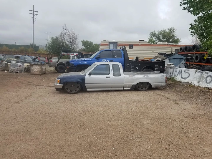 Abandoned trucks in a junkyard setting.