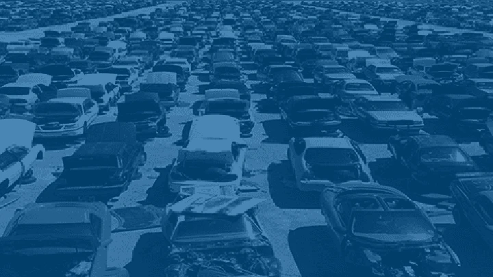 Aerial view of a car junkyard with numerous vehicles.