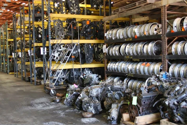 Auto parts warehouse displaying engines and wheels.