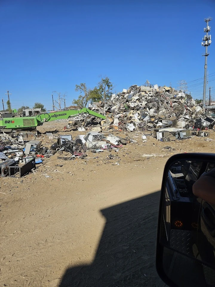 Auto recycling yard with machinery and scrap metal.