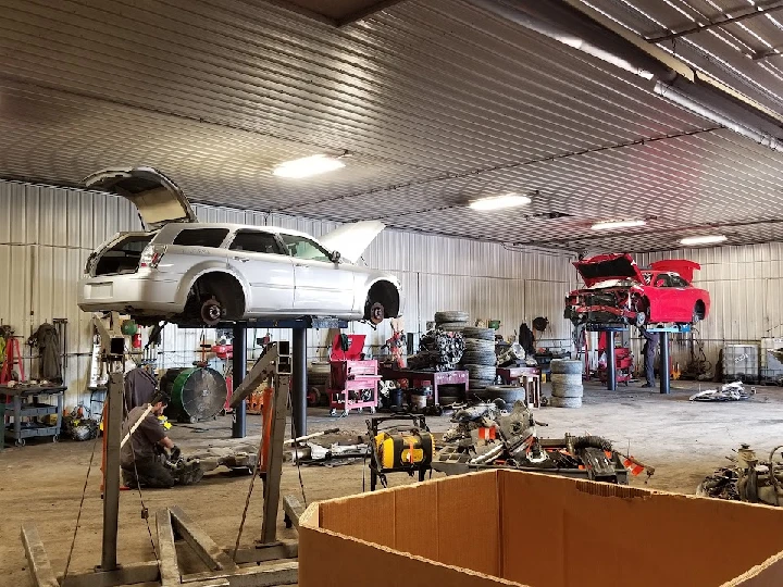 Auto repair shop with vehicles on lifts and tools.