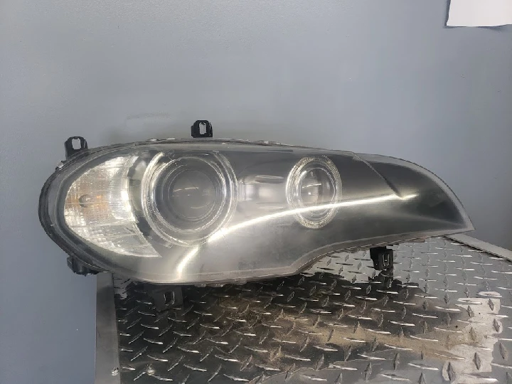 Automotive headlight assembly on stainless surface.