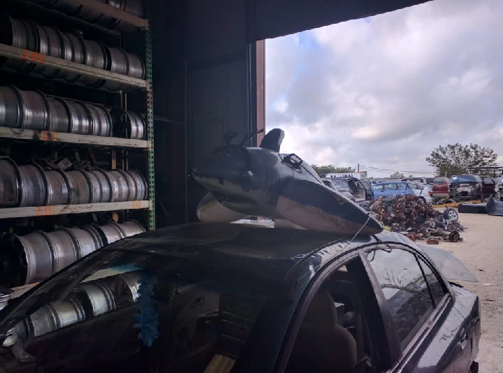 Bathtub toy on a car in an auto salvage yard.