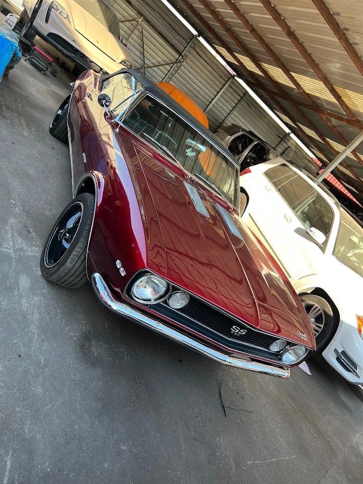 Classic red car in auto parts storage area.