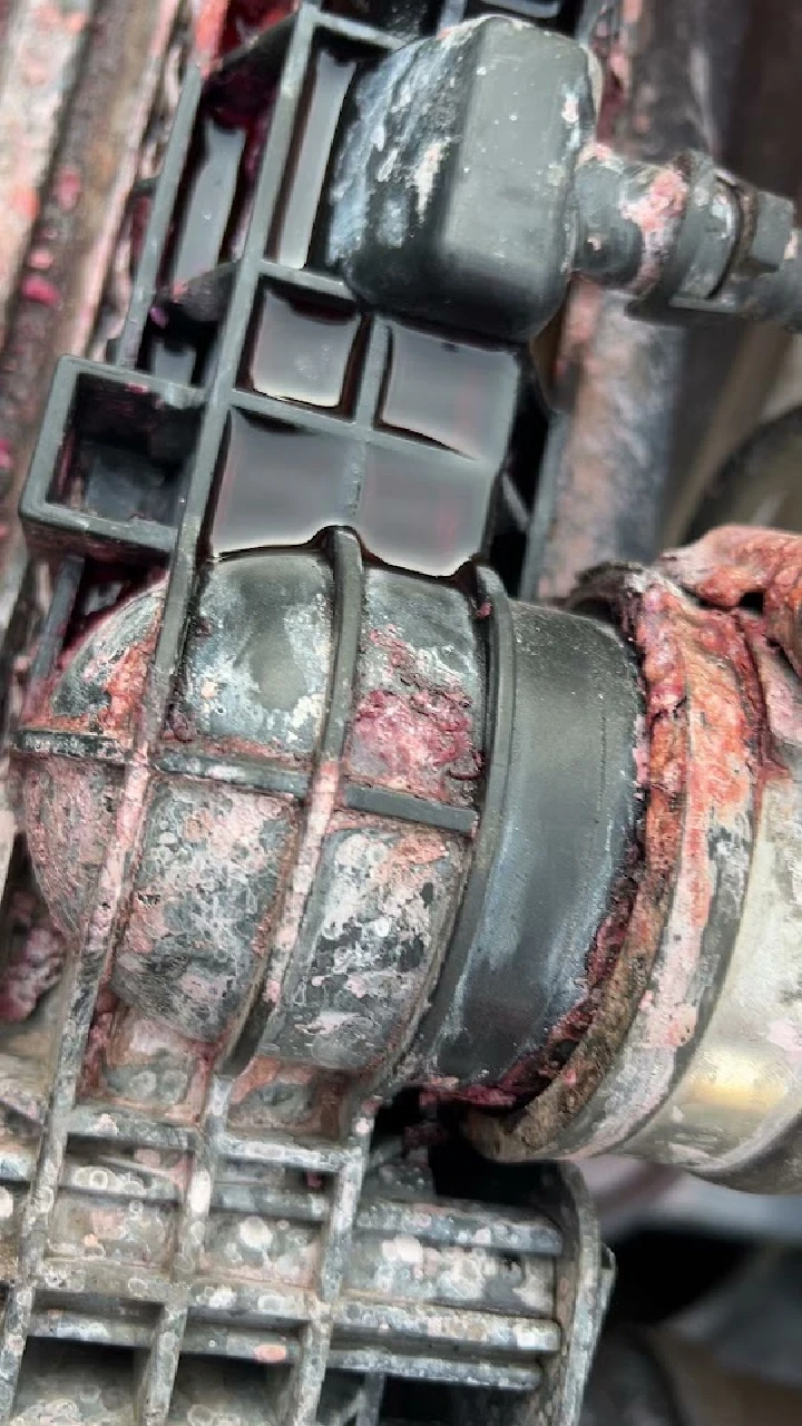 Close-up of a dirty, corroded engine component.