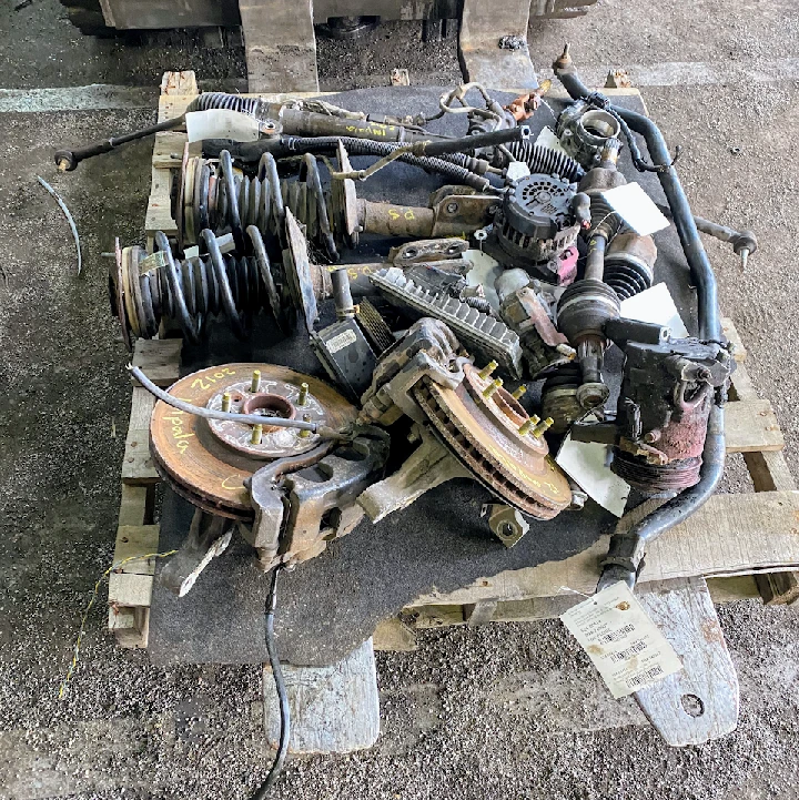 Collection of used auto parts on a wooden pallet.